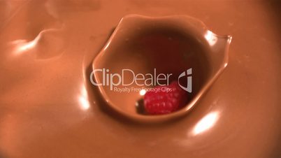Strawberry dropping into melted chocolate
