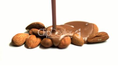 Melted chocolate being poured over almonds