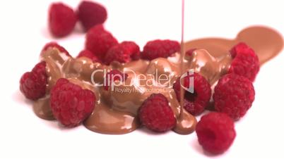 Chocolate pouring over raspberries