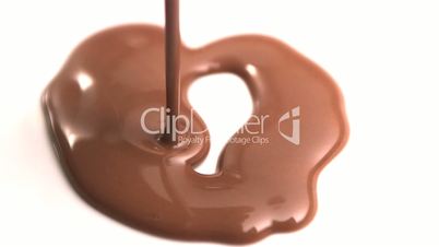 Melted chocolate pouring onto white surface