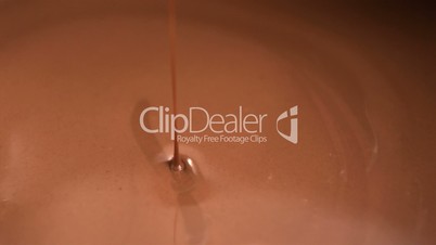 Melted chocolate being poured into pool of chocolate