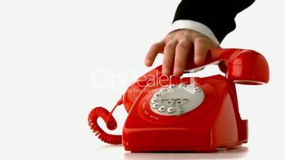 Hand putting receiver down on red dial phone