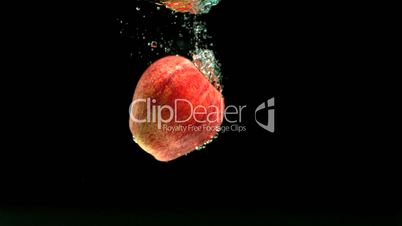 Apple falling in water and floating