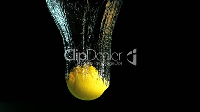 Lemon falling into water and floating