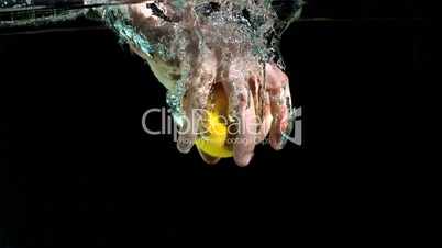 Hand grabbing lemon from water