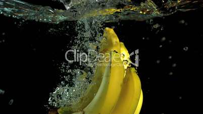 Bunch of bananas falling in water