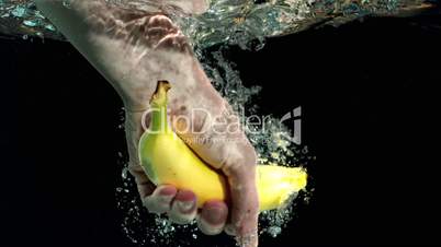 Hand taking a banana from water