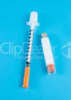 Insulin and syringe on a blue background