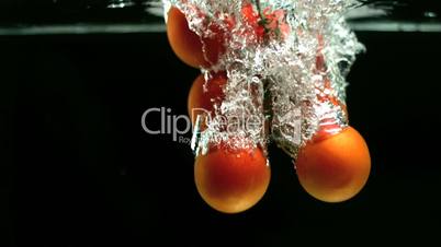 Tomatoes dropping in water