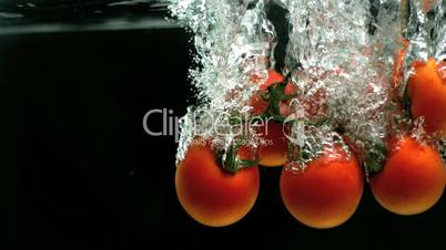 Vine tomatoes falling into water