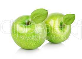 Two green apples with leaves