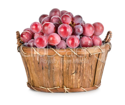 Dark blue grapes in a wooden basket isolated
