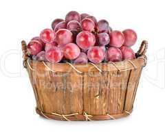 Dark blue grapes in a wooden basket isolated