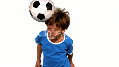 Boy jumping and heading football