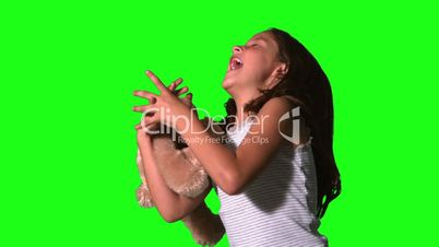 Little girl twirling and catching teddy on green screen