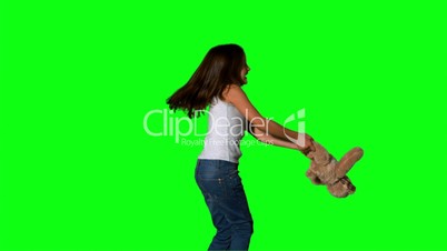 Little girl throwing and catching teddy on green screen