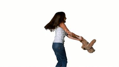 Little girl throwing and catching teddy on white background