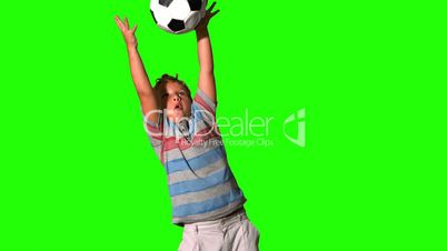 Boy catching football on green screen