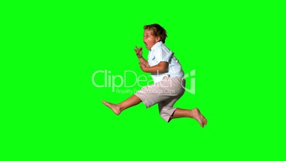 Little boy jumping and shouting on green screen side view