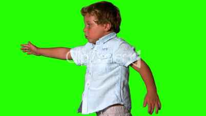 Little boy jumping and turning on green screen