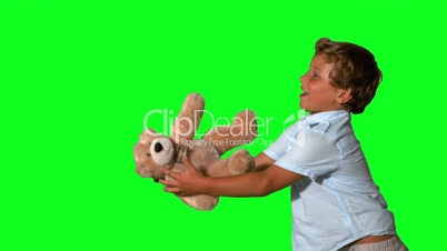 Little boy jumping and catching teddy on green screen