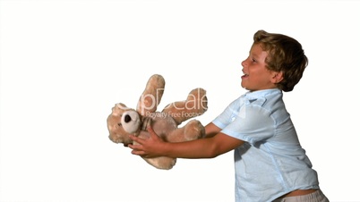 Little boy jumping and catching teddy on white background