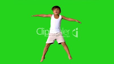 Happy little boy jumping on green screen