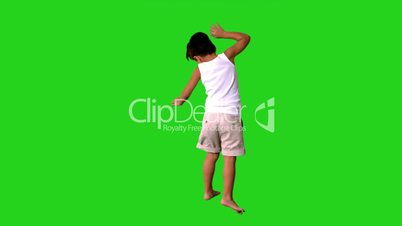 Happy little boy jumping and spinning on green screen