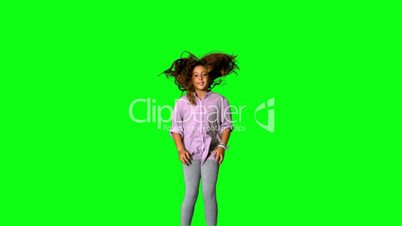Happy little girl jumping up and down on green screen