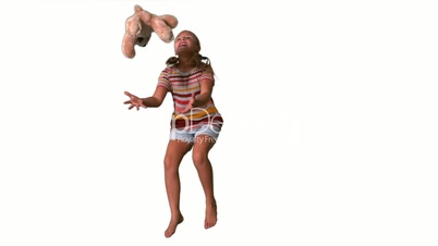 Girl jumping and catching teddy on white background