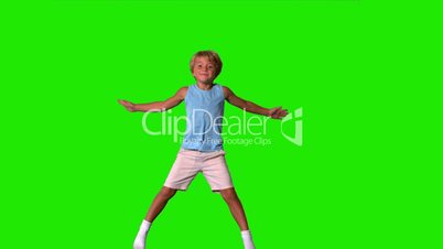 Boy jumping with limbs outstretched on green screen