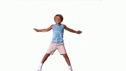 Boy jumping with limbs outstretched on white background