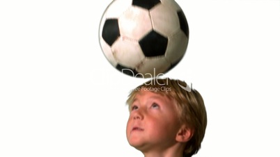 Little boy heading football on white background