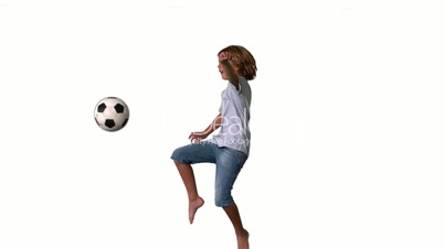 Boy jumping and kicking football on white background