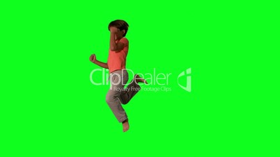 Side view of boy jumping up and down on green screen