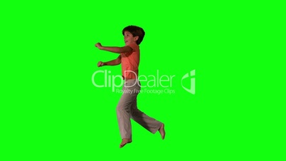 Side view of happy boy jumping up and down on green screen