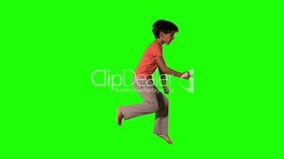 Boy jumping on green screen side view