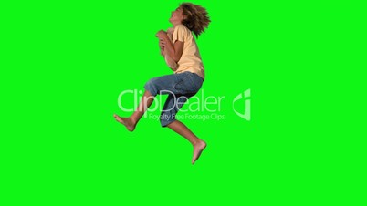 Boy jumping to catch teddy bear on green screen