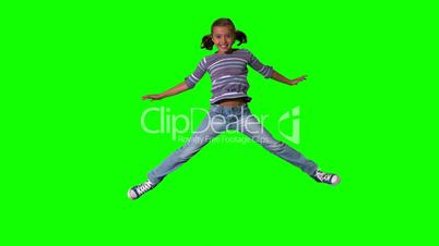 Happy girl jumping up and down on a green screen