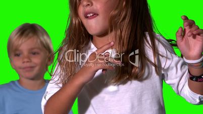 Cute siblings jumping together on green screen