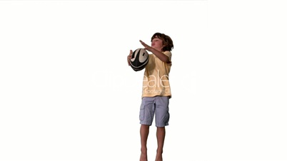 Little boy jumping up and catching a rugby ball on white background