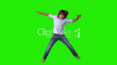 Little boy jumping up in shirt and jeans on green screen