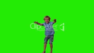 Boy in denim shorts jumping on green screen