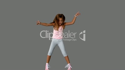 Little girl jumping on grey background