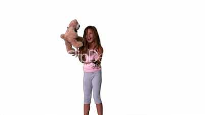 Little girl jumping up and catching teddy on white background