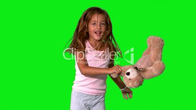 Little girl jumping up and down and turning with teddy on green screen