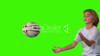 Boy catching rugby ball on green screen