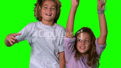 Brother and sister jumping up on green screen