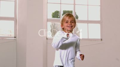 Boy in pajamas jumping and yelling in front of window