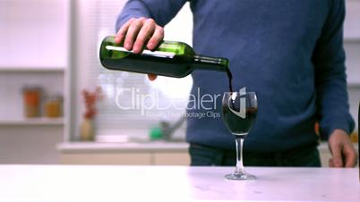 Man pouring red wine into a glass